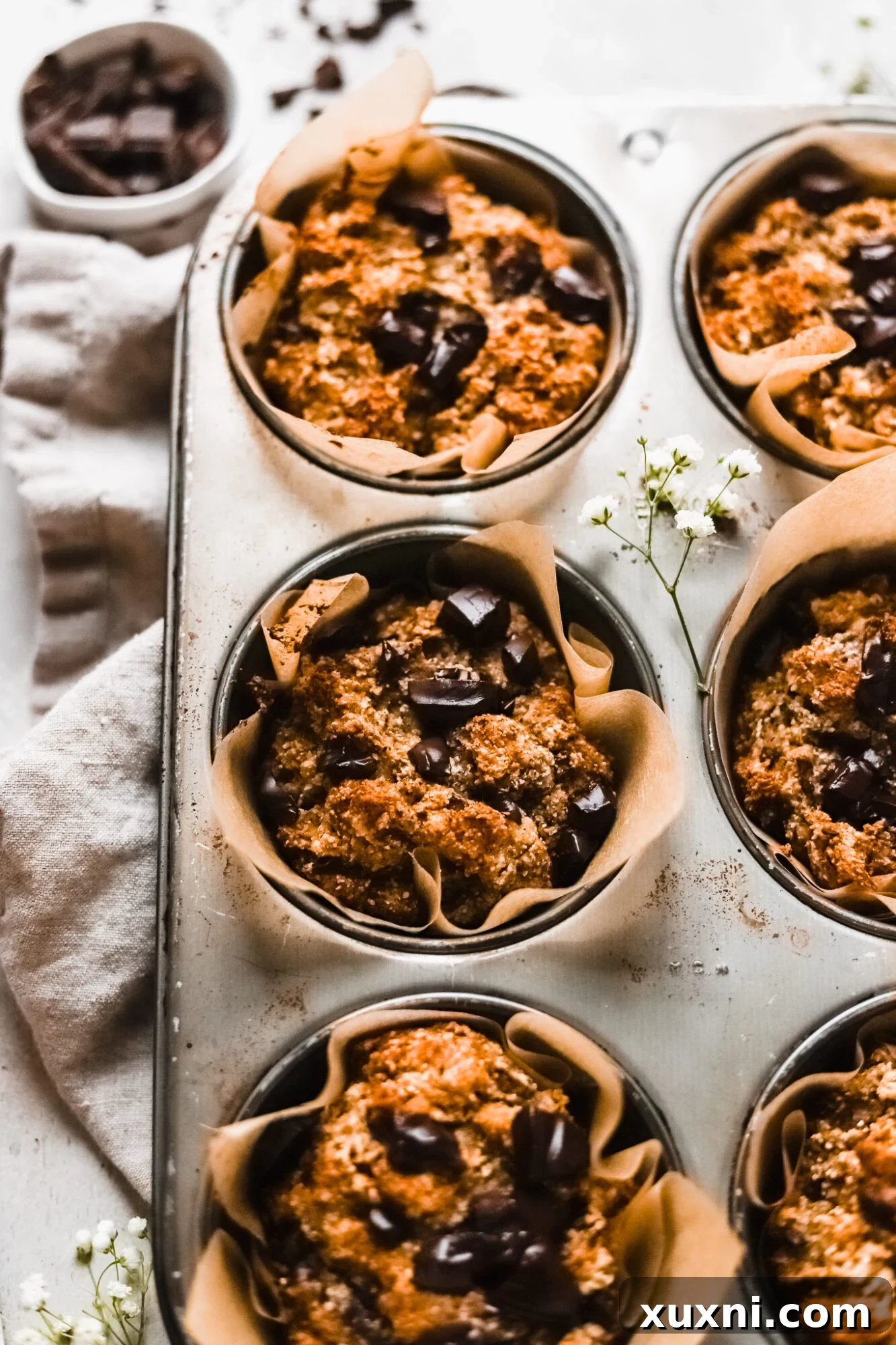 Close-up shot of a perfectly baked Paleo banana muffin with visible chocolate chips, showcasing its soft texture.