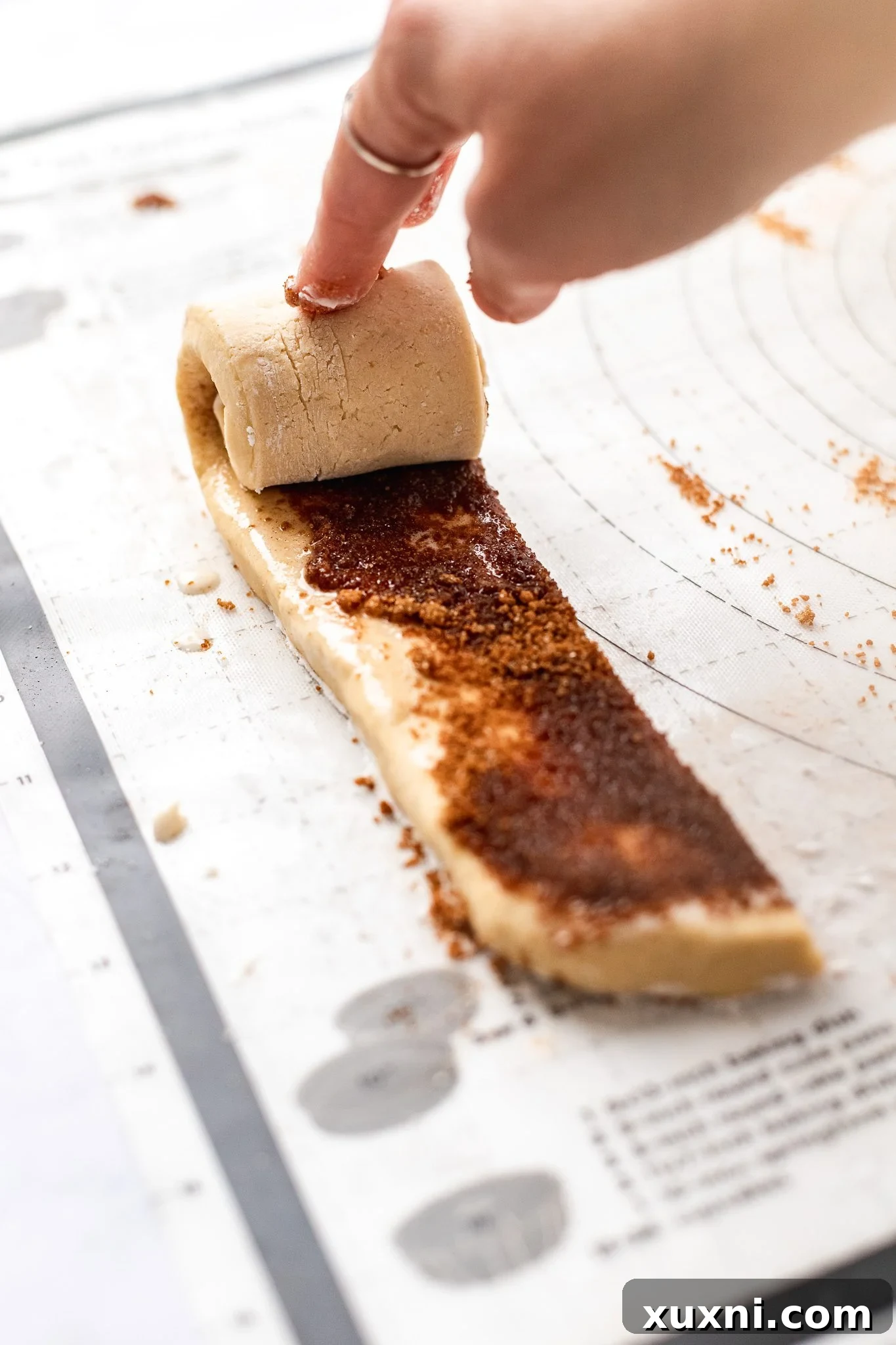hand rolling cinnamon roll dough