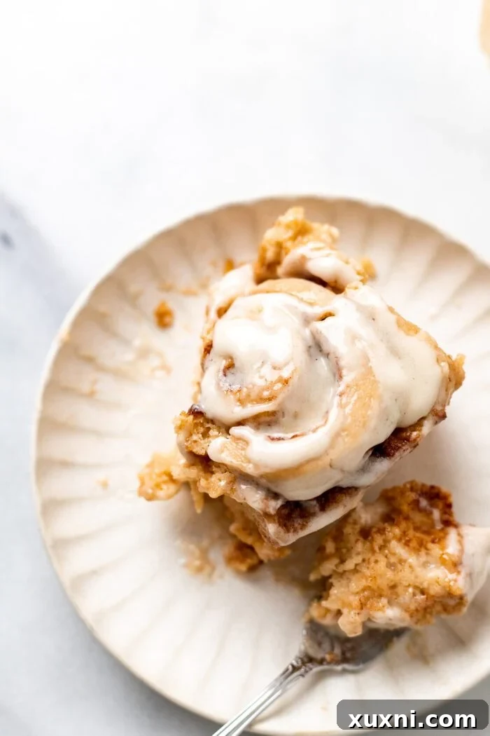 gluten free cinnamon roll on a plate with a bite taken out