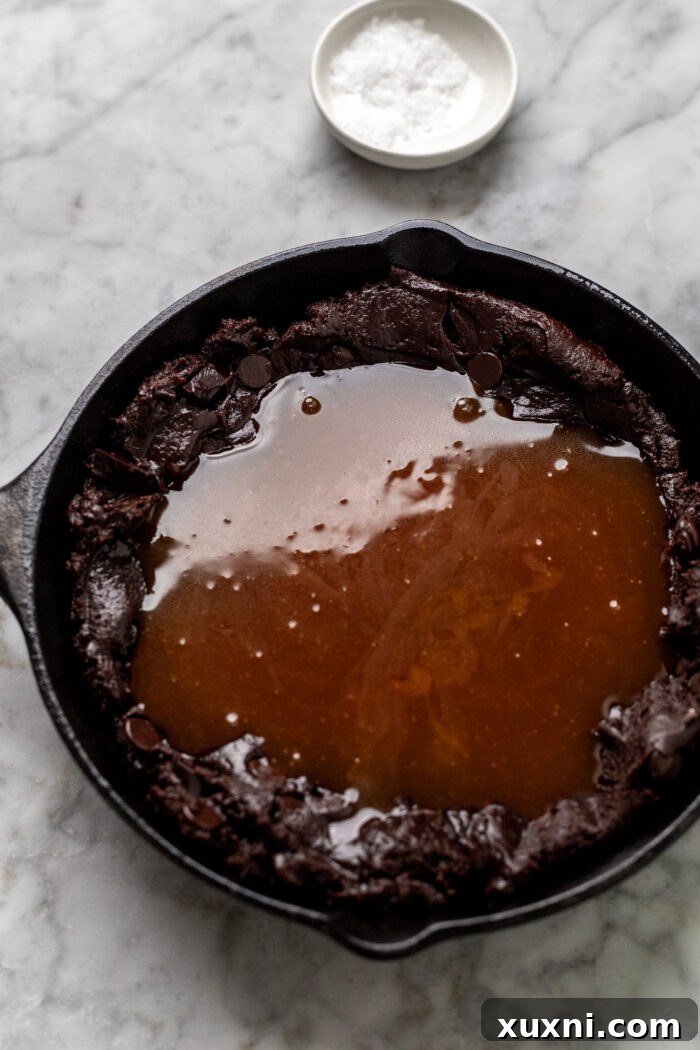 Cookie skillet layered with caramel before adding top dough layer