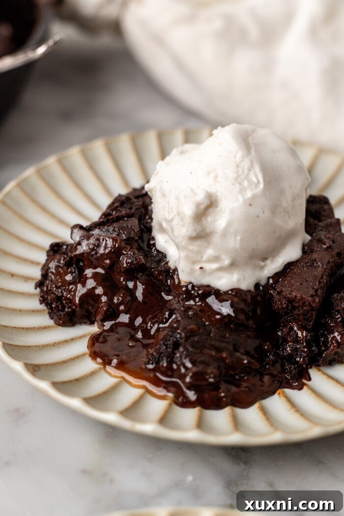 Scoop of vegan vanilla ice cream melting on a warm chocolate caramel cookie skillet