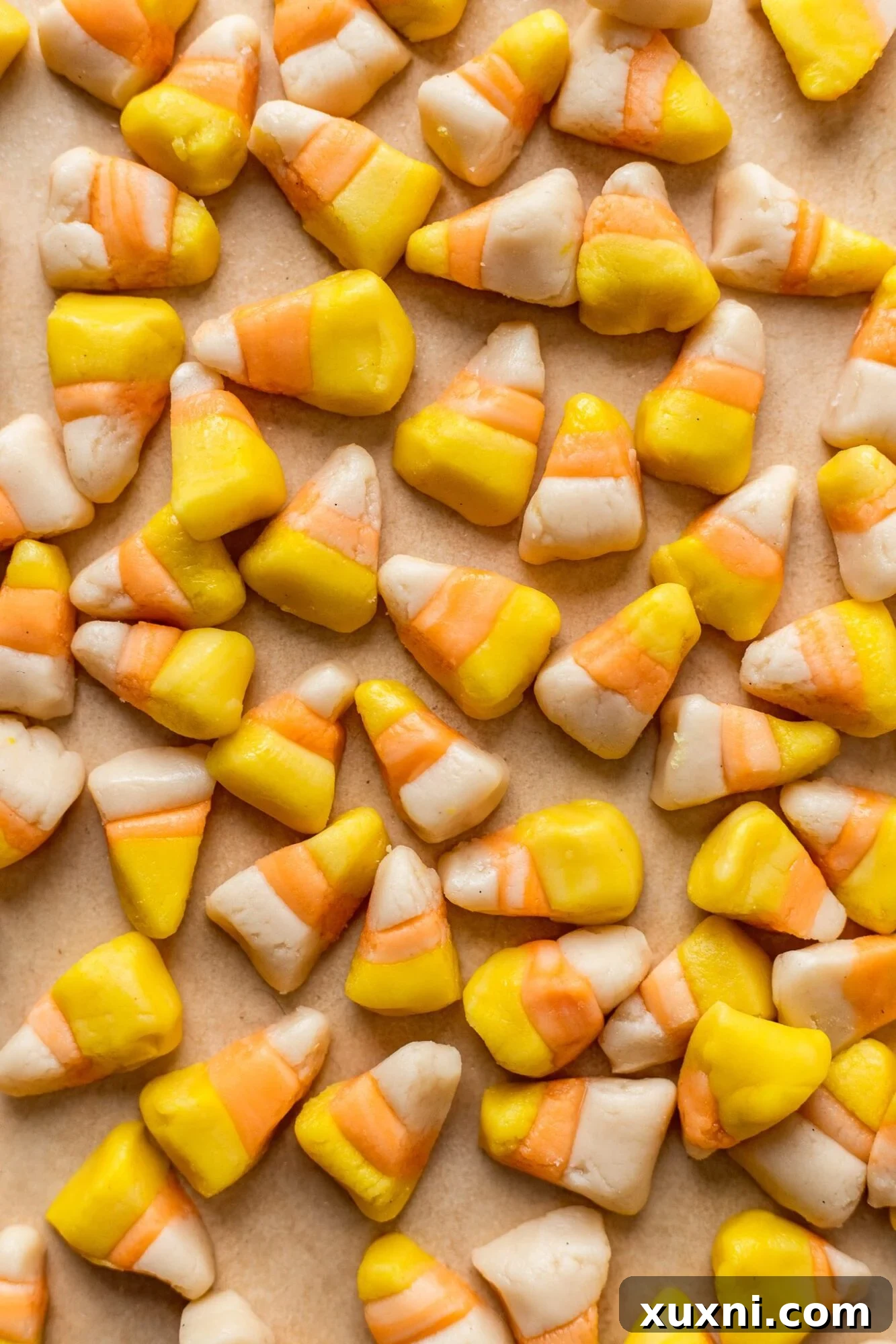 Vibrant homemade vegan candy corn triangles arranged for Halloween. Made with maple syrup and free of dairy and gelatin.