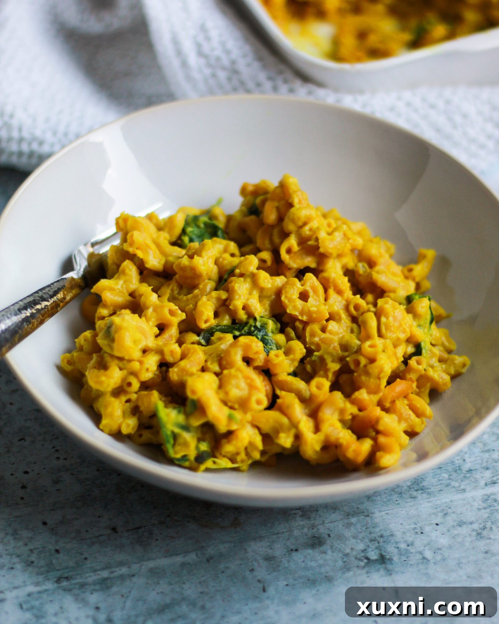 A beautifully presented bowl of vibrant yellow vegan macaroni and cheese, ready to be enjoyed.