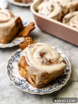 Gingerbread cinnamon rolls on a plate, frosted and ready to serve.