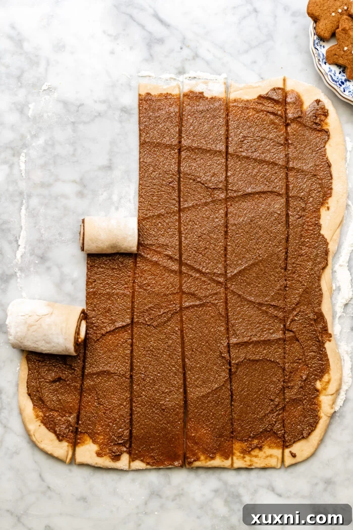 Gingerbread filling being spread evenly over the rolled-out dough.