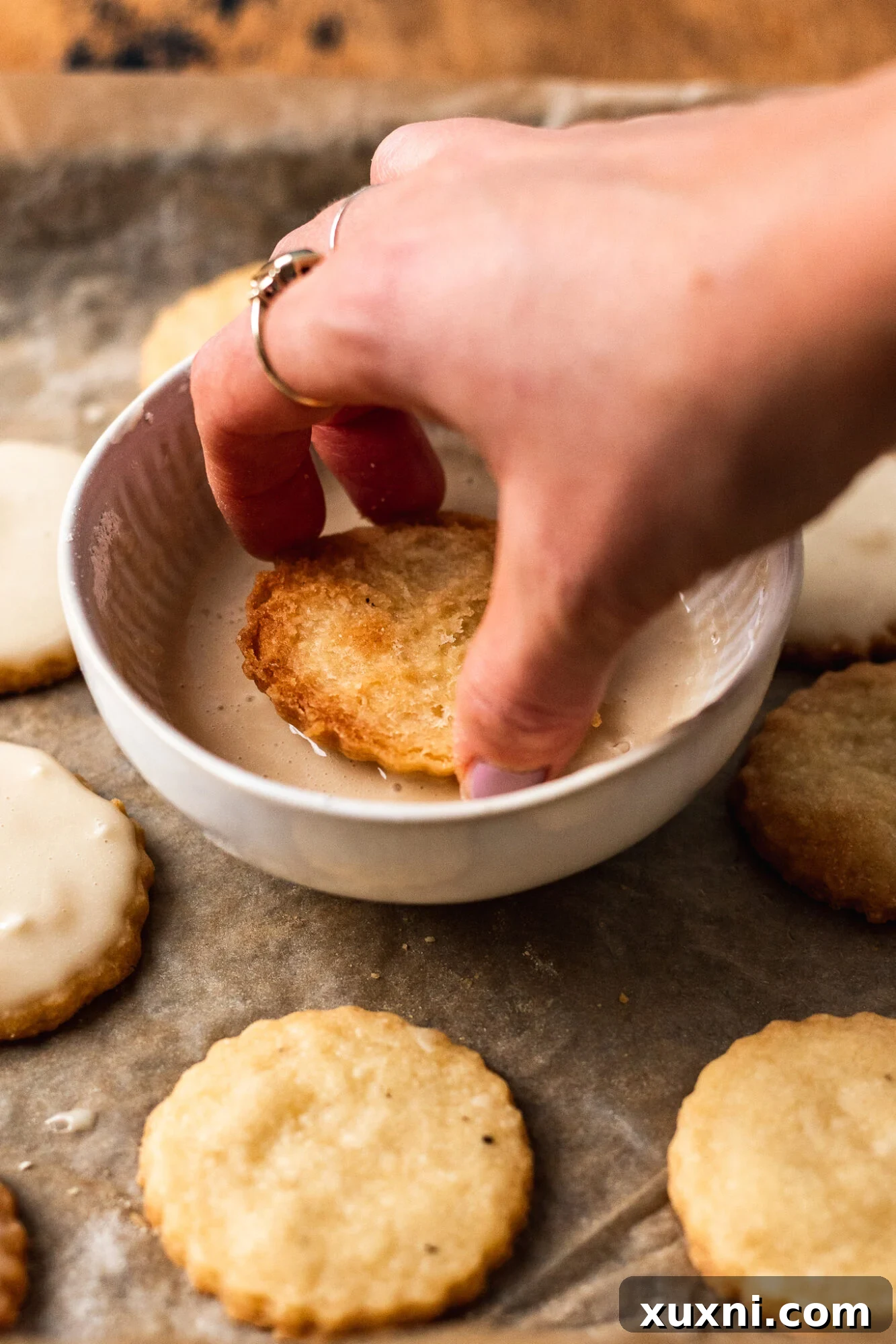 Decorating vegan shortbread cookies with pink buttercream Christmas trees
