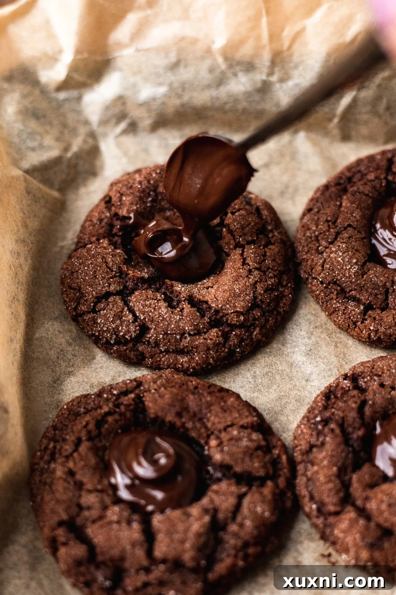 Vegan chocolate thumbprint cookies being filled with ganache