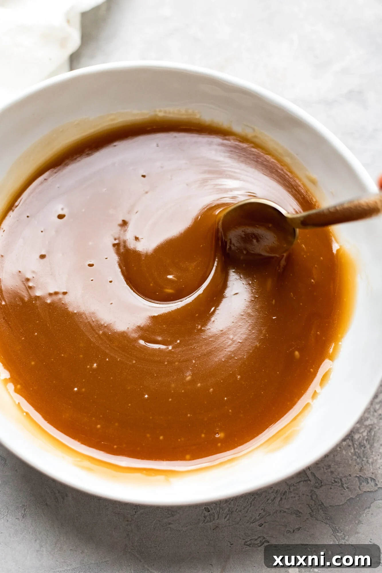 Simply Divine Vegan Sticky Toffee Pudding 4 A saucepan filled with ingredients for vegan toffee sauce, actively simmering to thicken.