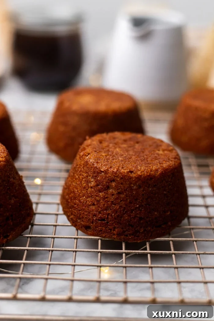 Simply Divine Vegan Sticky Toffee Pudding 9 Freshly baked vegan sticky toffee puddings cooling on a wire rack after being flipped from the muffin tin.