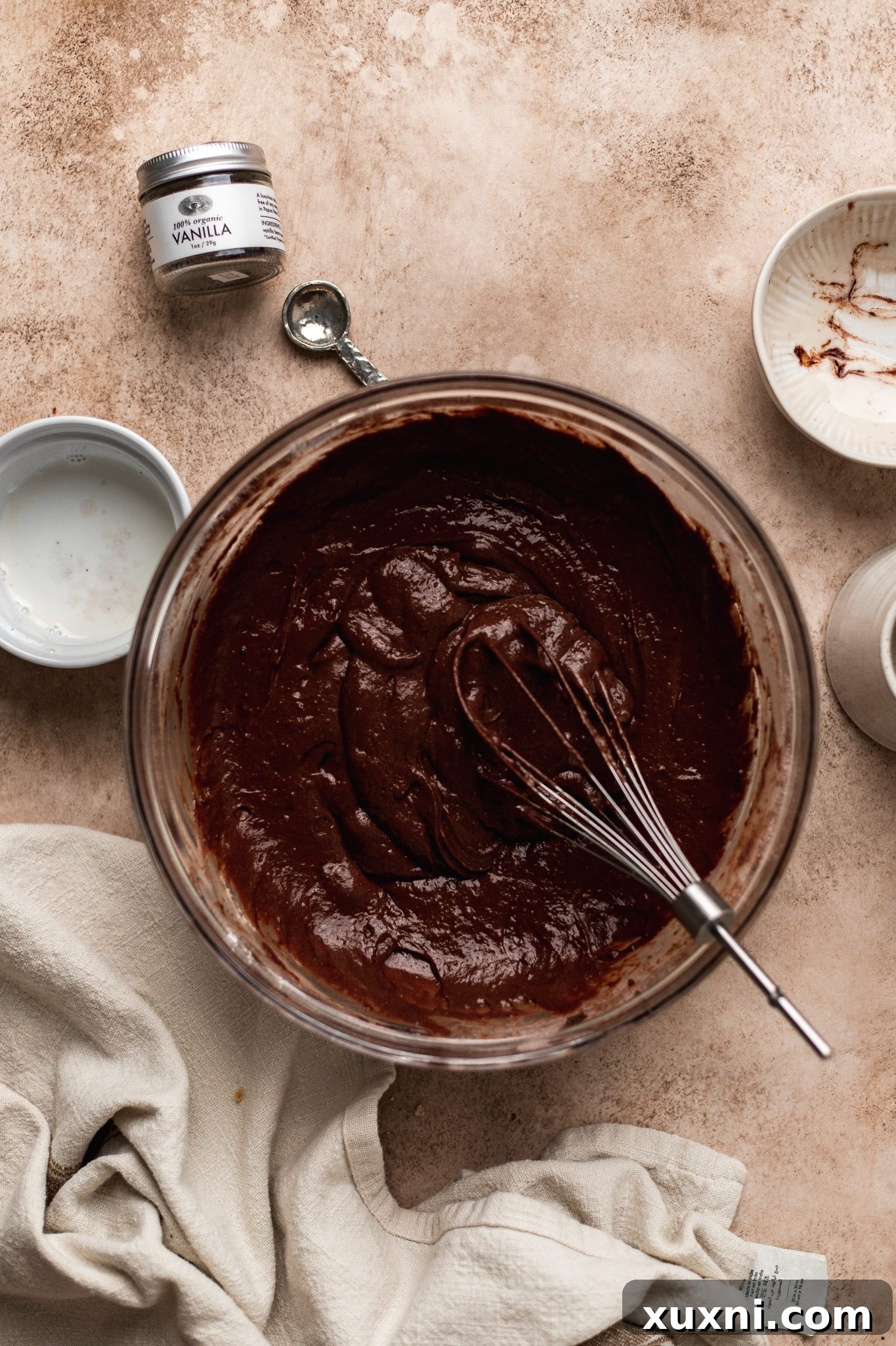 Mixing wet ingredients with dry ingredients to form the vegan chocolate donut batter.