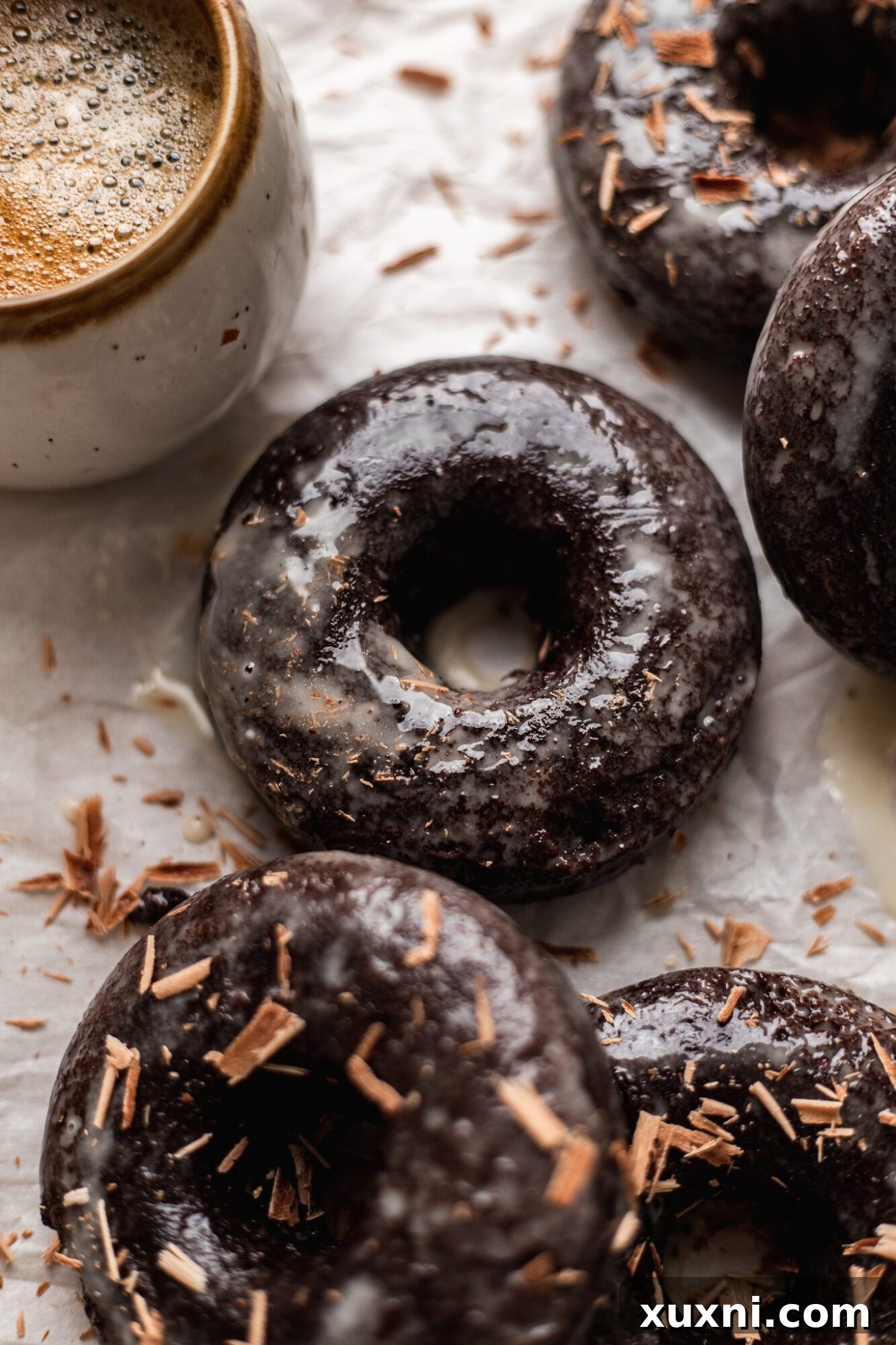 Close-up of a single baked vegan chocolate donut, showcasing its rich brown color and tender texture.