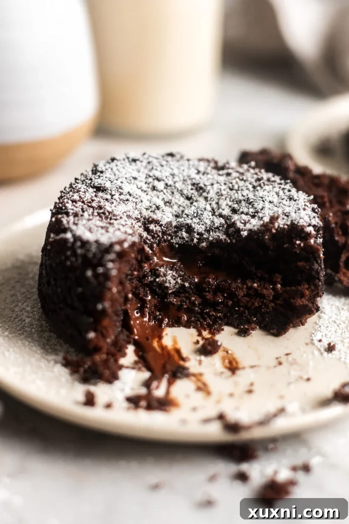 A sliced vegan molten lava cake revealing its perfectly gooey chocolate center.