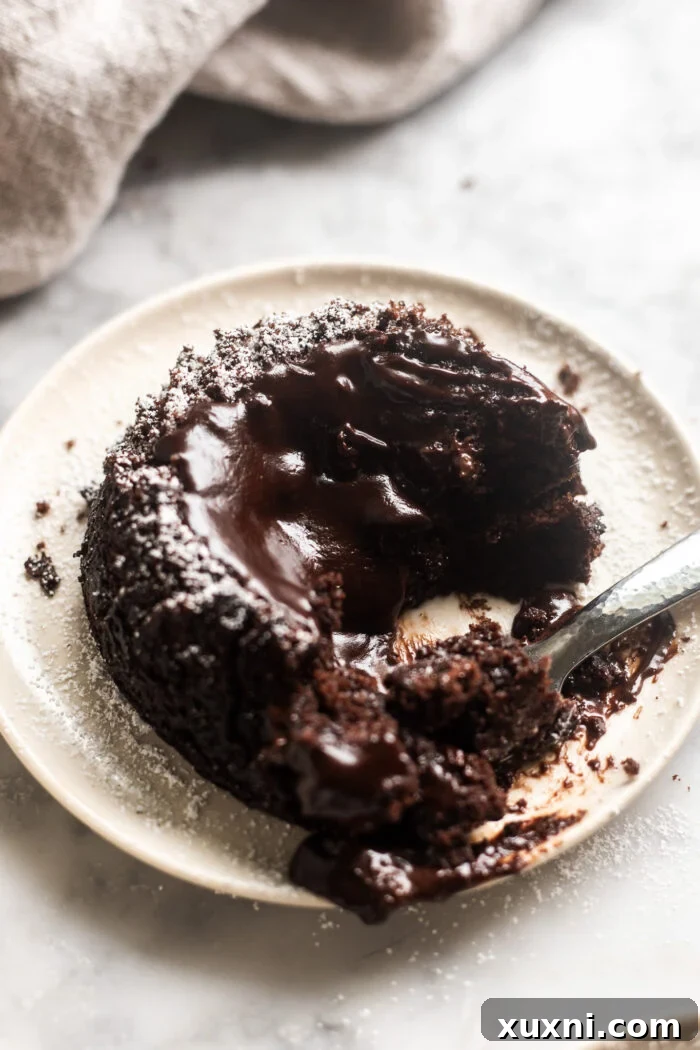 A vegan lava cake on a plate with a bite taken, showing the rich melted center.