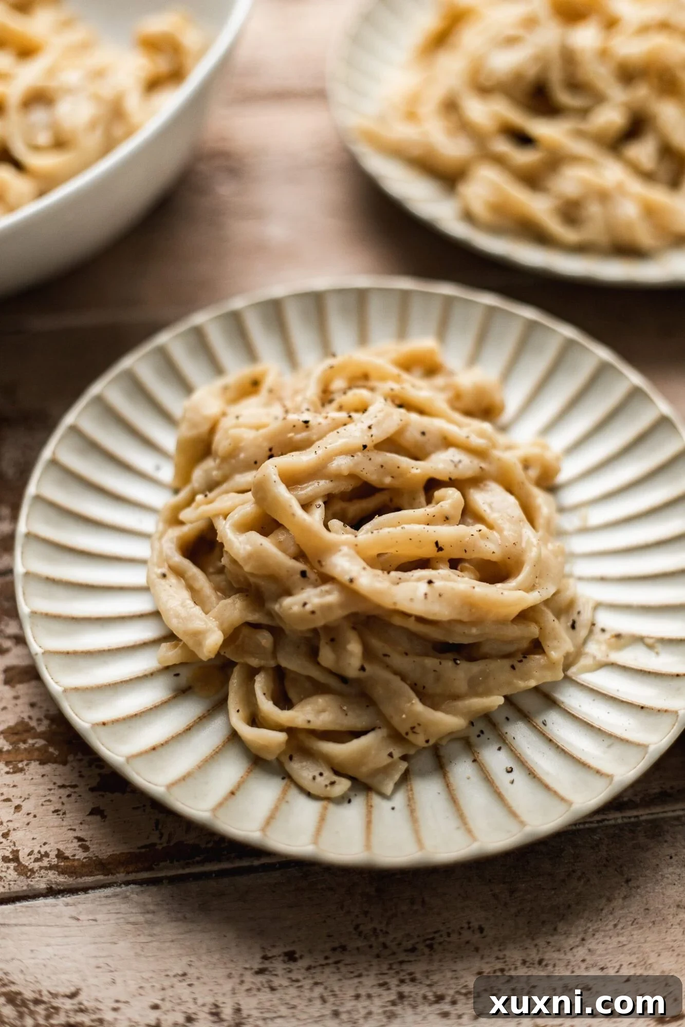 Unbelievably Creamy Nut-Free Vegan Cacio e Pepe 2 A vibrant bowl of creamy vegan cacio e pepe, garnished with fresh black pepper, showcasing its rich, dairy-free sauce and perfectly cooked pasta.