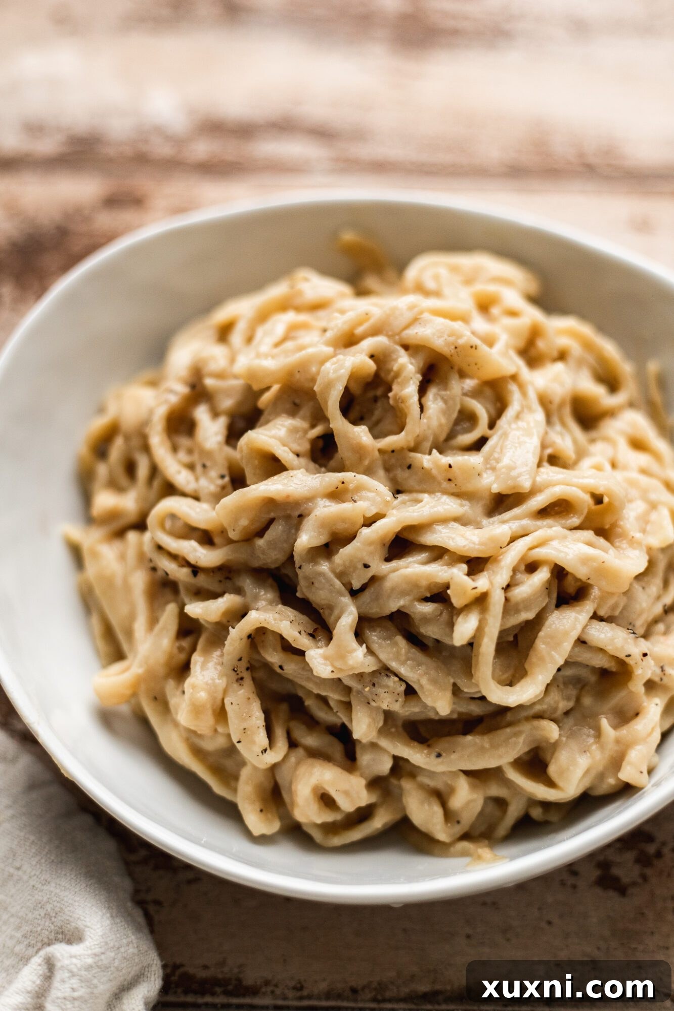 Unbelievably Creamy Nut-Free Vegan Cacio e Pepe 3 A close-up shot of creamy vegan cacio e pepe in a bowl, showing the thick, rich sauce coating the pasta strands, ready to be enjoyed.