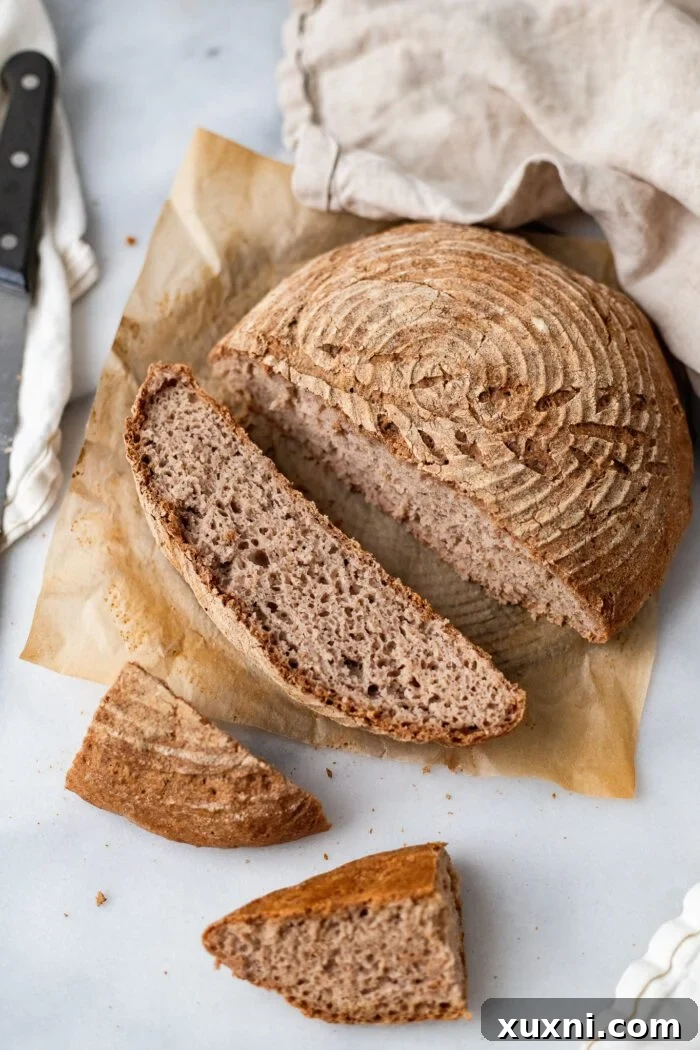 Freshly baked gluten-free vegan artisan bread, sliced open to show its airy texture and golden crust