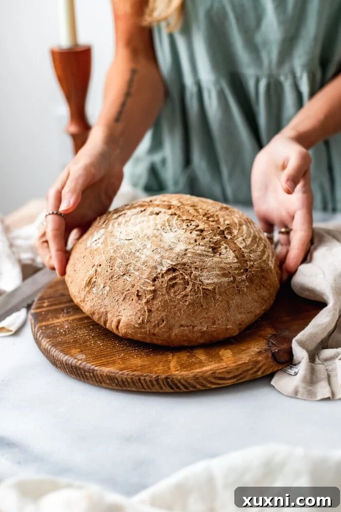 Close-up of a gluten-free bread dough with a beautifully scored wheat leaf design before baking.