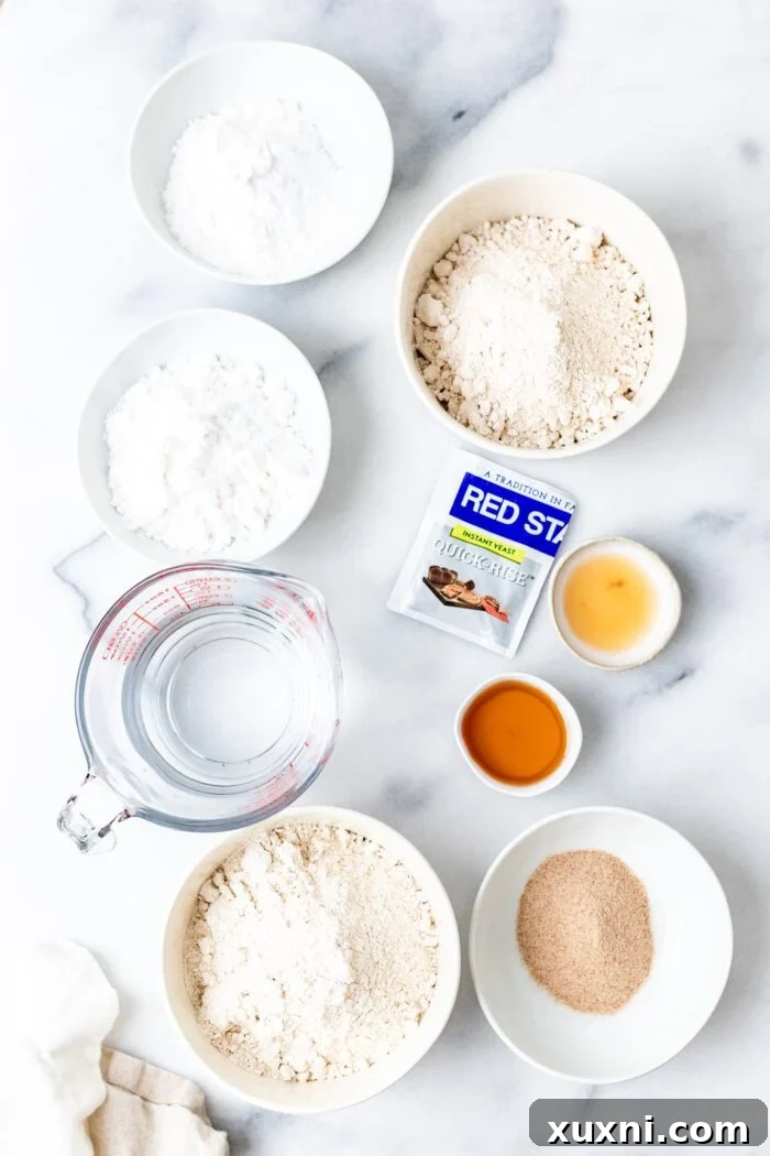 Arrangement of essential gluten-free bread ingredients on a countertop, including flours, yeast, and psyllium husk.