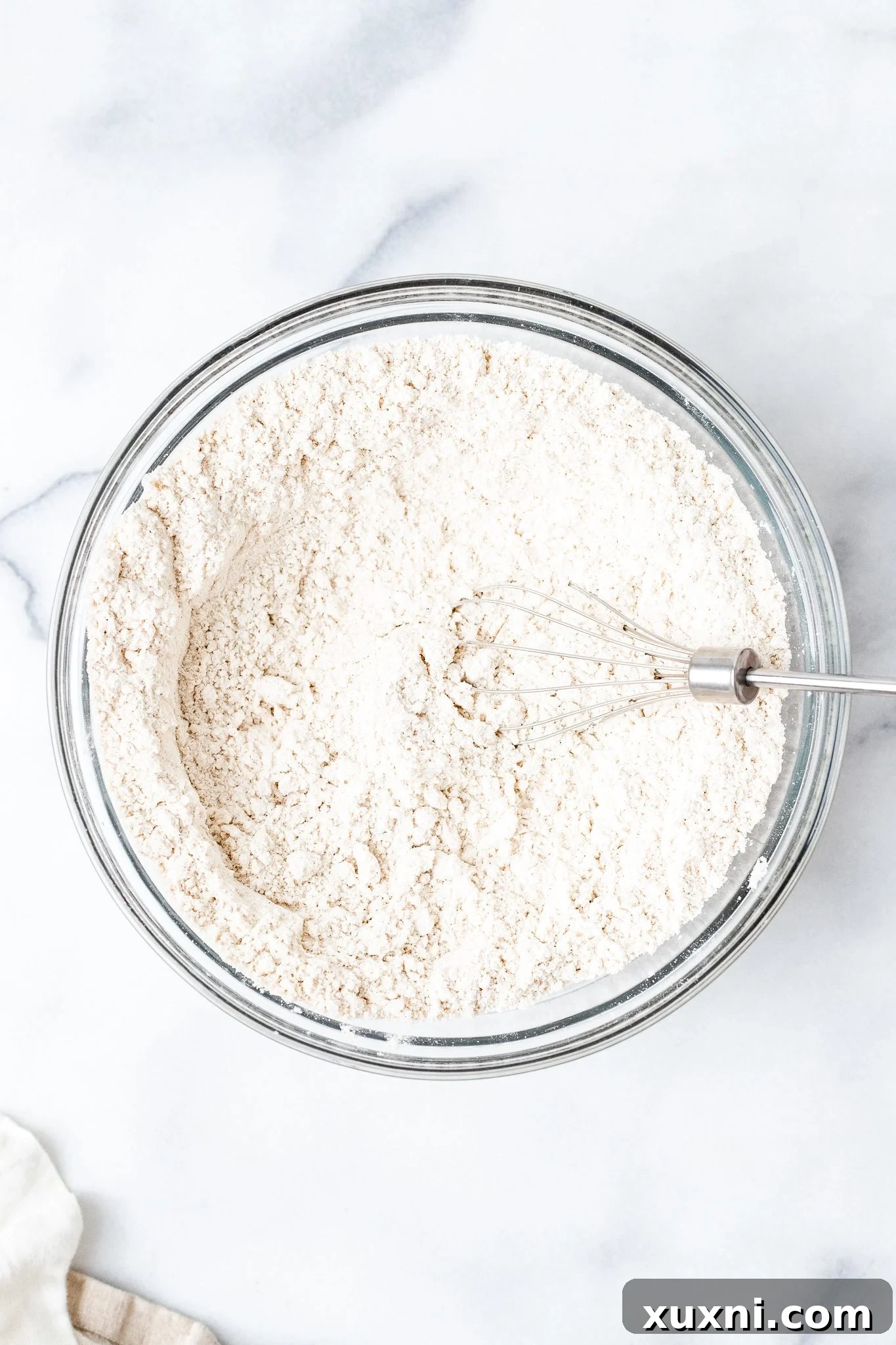A bowl containing various dry gluten-free flours and salt, perfectly whisked together before liquid ingredients are added.