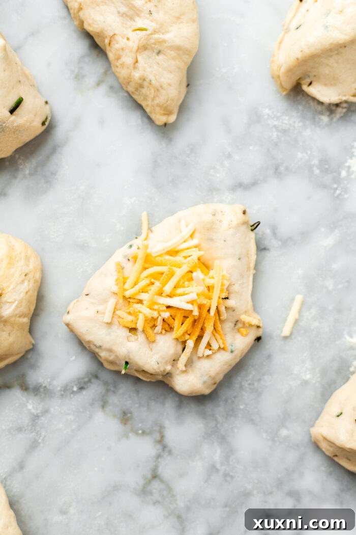 adding vegan shredded cheese to the center of a dough piece