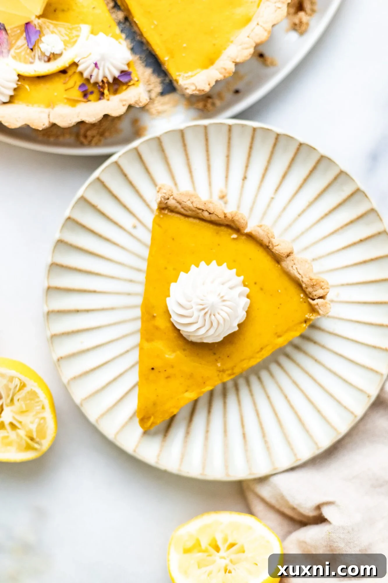Close-up of a perfectly sliced vegan lemon tart, revealing its creamy texture and the golden color of the filling.