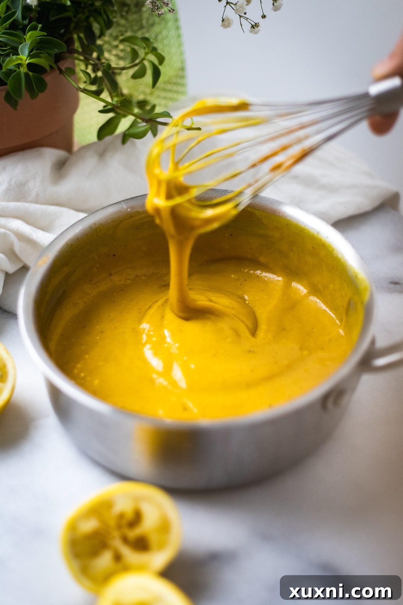 Thickened vegan lemon custard in a saucepan after vegan butter has been added.