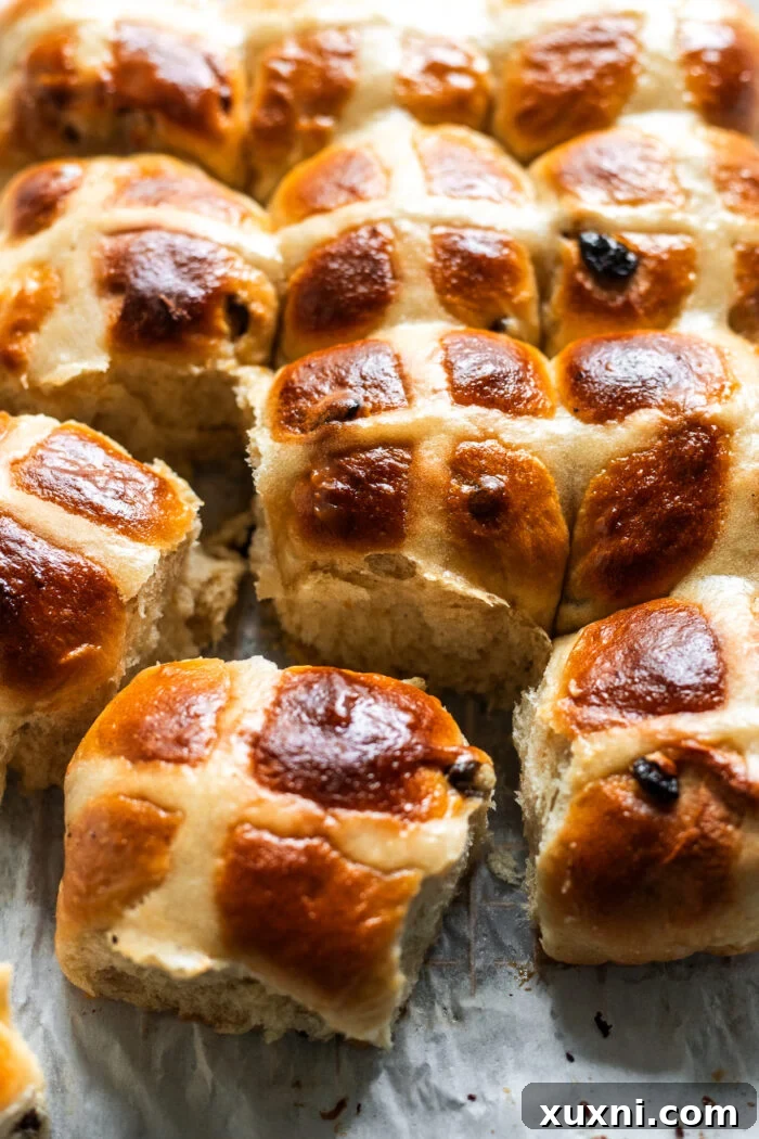 Whip Up Simple & Scrumptious Vegan Hot Cross Buns 3 vegan hot cross buns on parchment paper