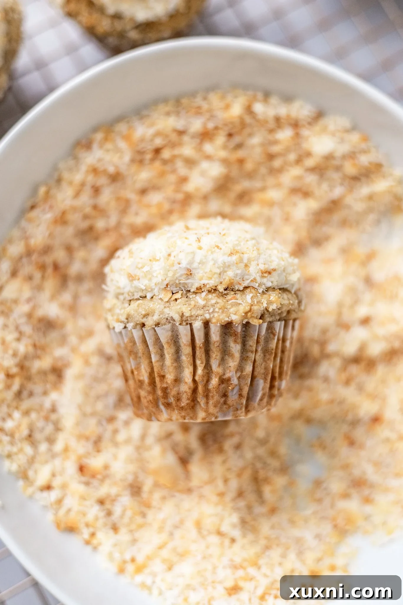 Decadent Vegan Coconut Cupcakes Gluten Free Adaptable 10 dipping the coconut cupcake into coconut shreds