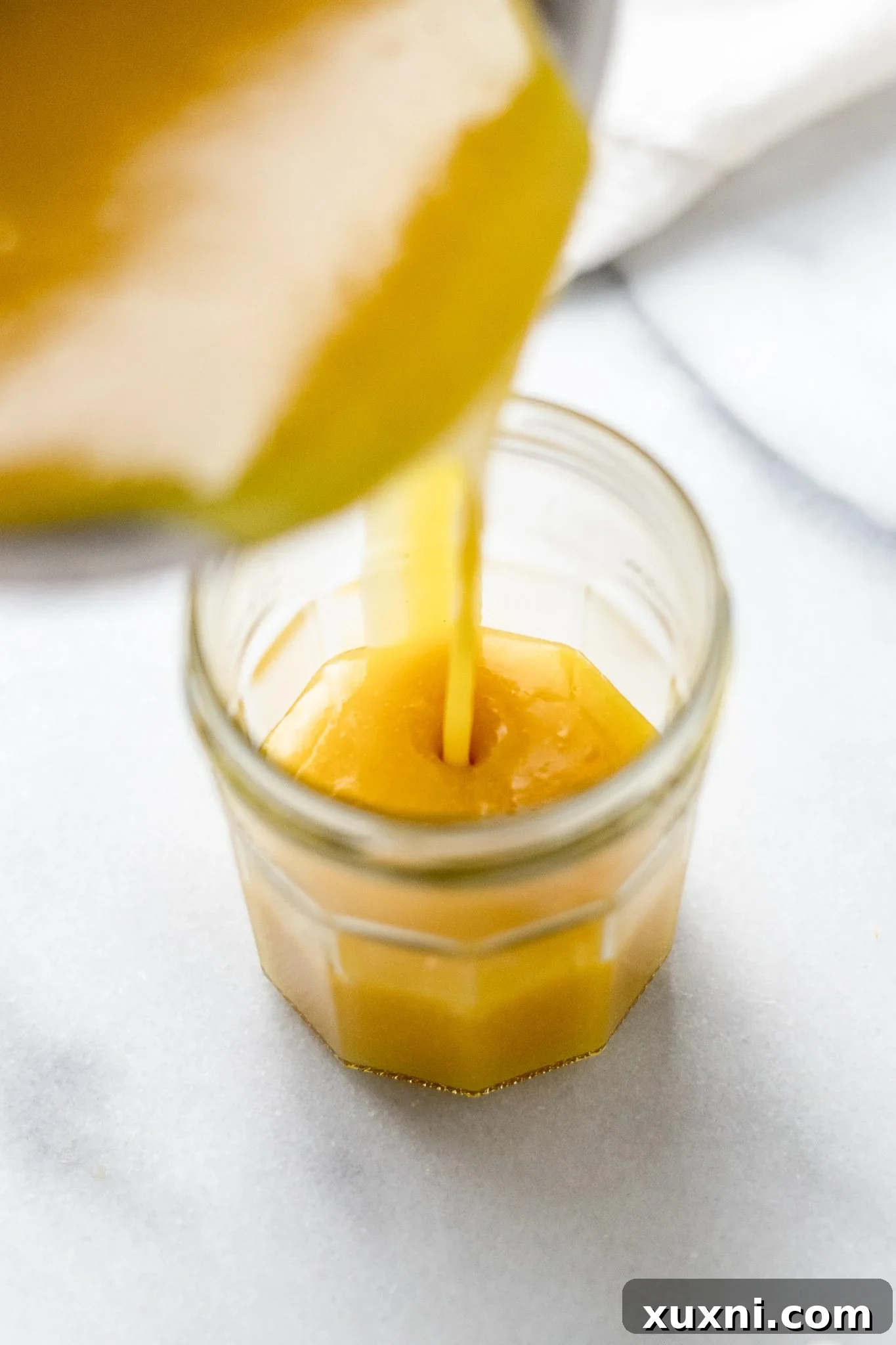 pouring lemon curd into a jar