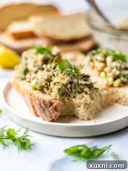 vegan tuna salad on slice of bread on a plate with dill and parsley