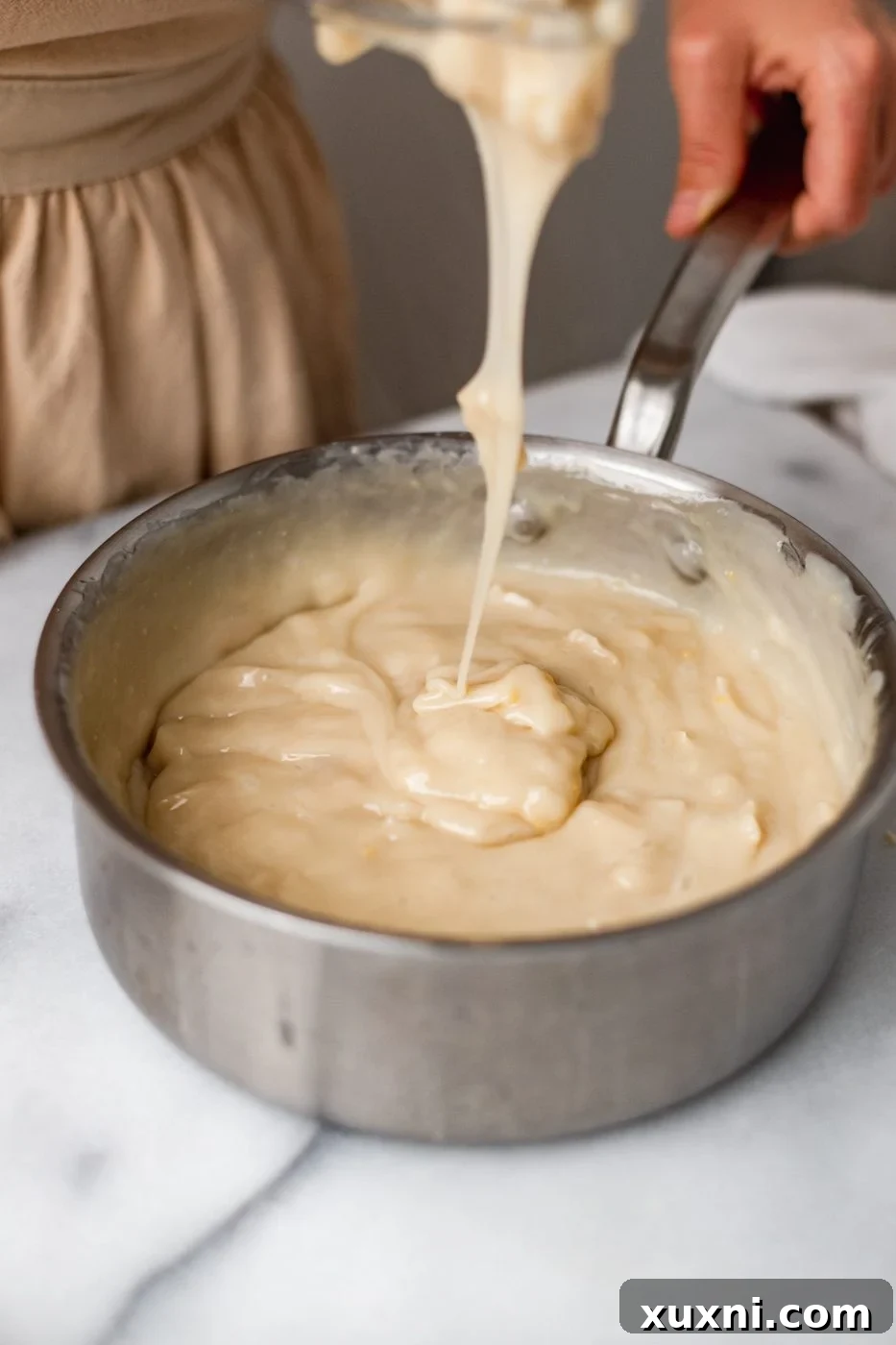 A close-up of the fully thickened coconut cream pie filling, showcasing its smooth and rich consistency.