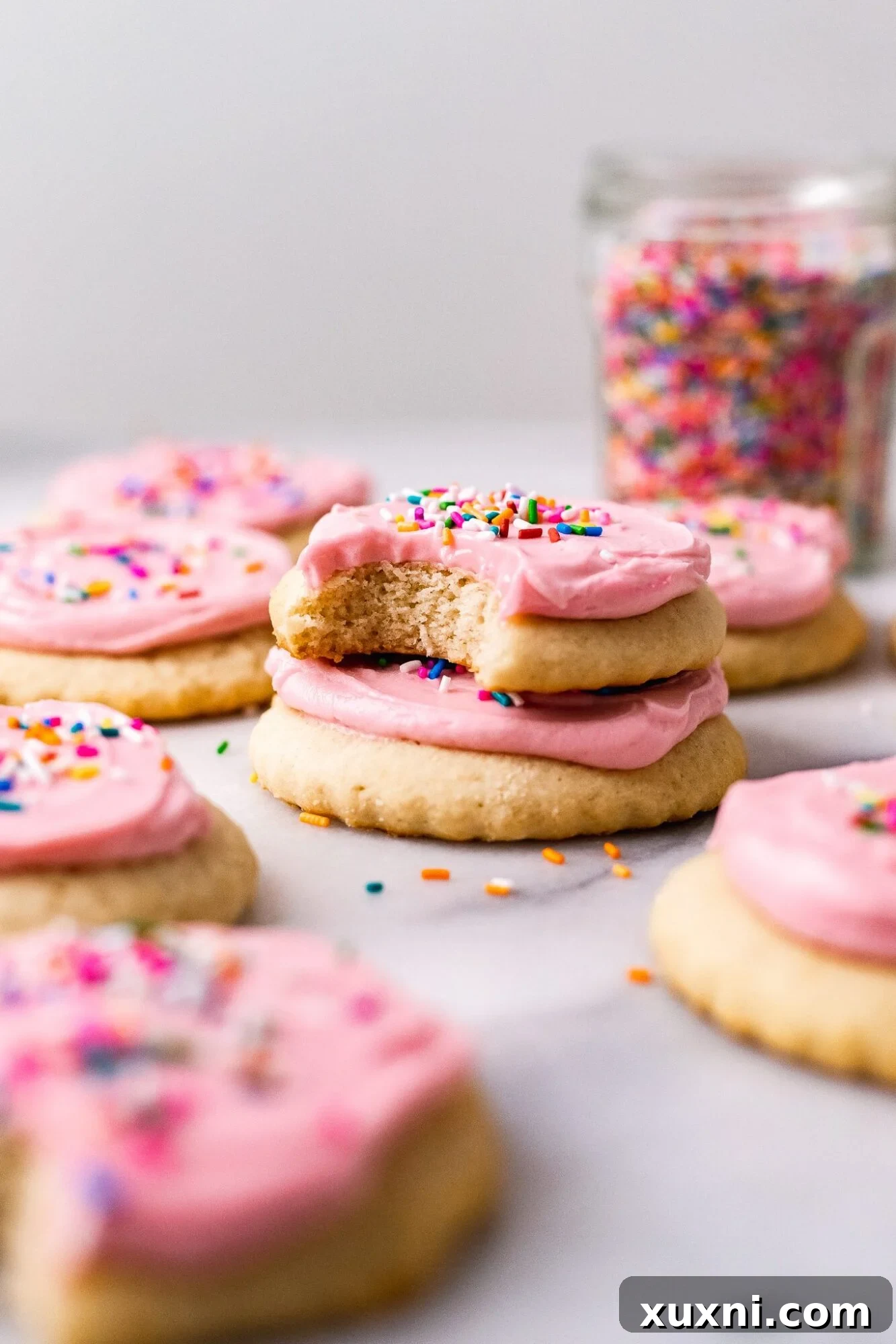 stacked vegan Lofthouse Cookies with pink frosting and sprinkles