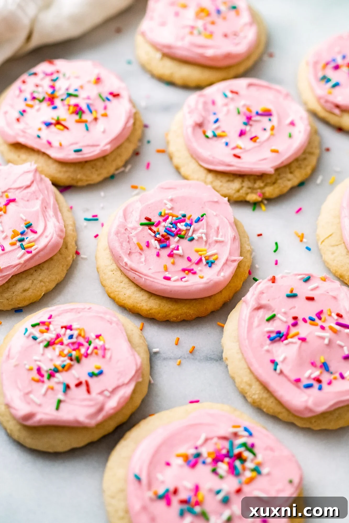 vegan Lofthouse Cookies on marble countertop with pink frosting and sprinkles