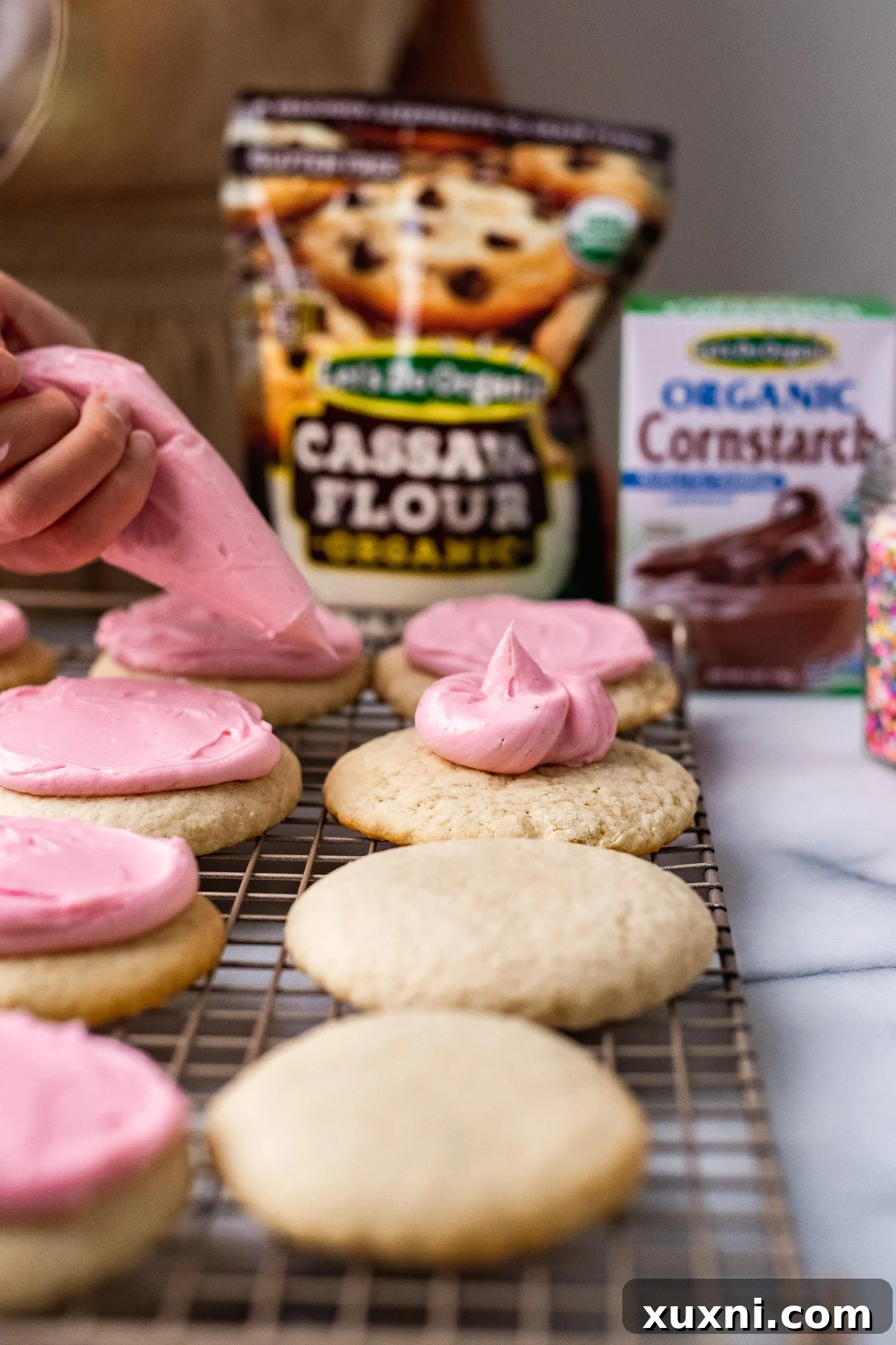 piping the frosting onto cookies for easy spreading