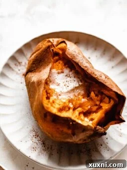 sliced sweet potato with pat of vegan butter on white plate