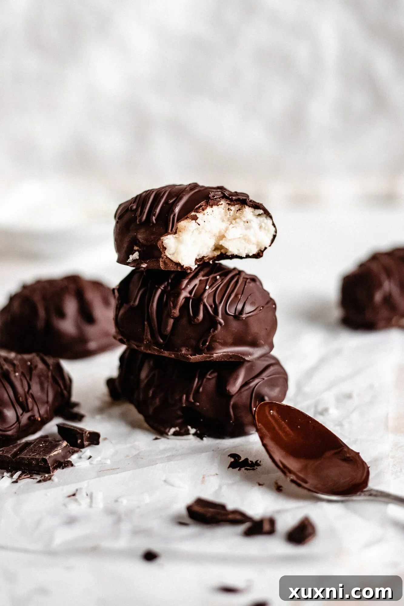 Stack of luscious Paleo vegan coconut cream eggs, coated in rich chocolate, ready for an Easter celebration.