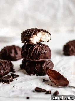 Stack of Paleo vegan coconut cream eggs, coated in rich chocolate, a perfect Easter treat.