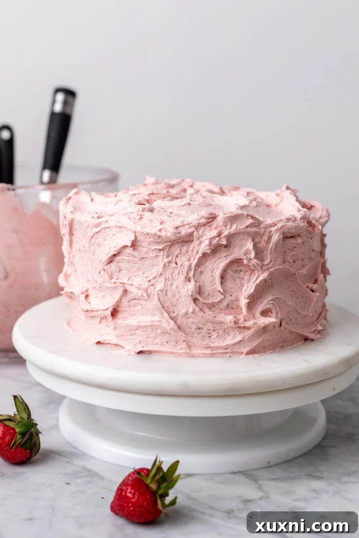 A beautifully decorated vegan strawberry cake, freshly frosted and ready to be served.