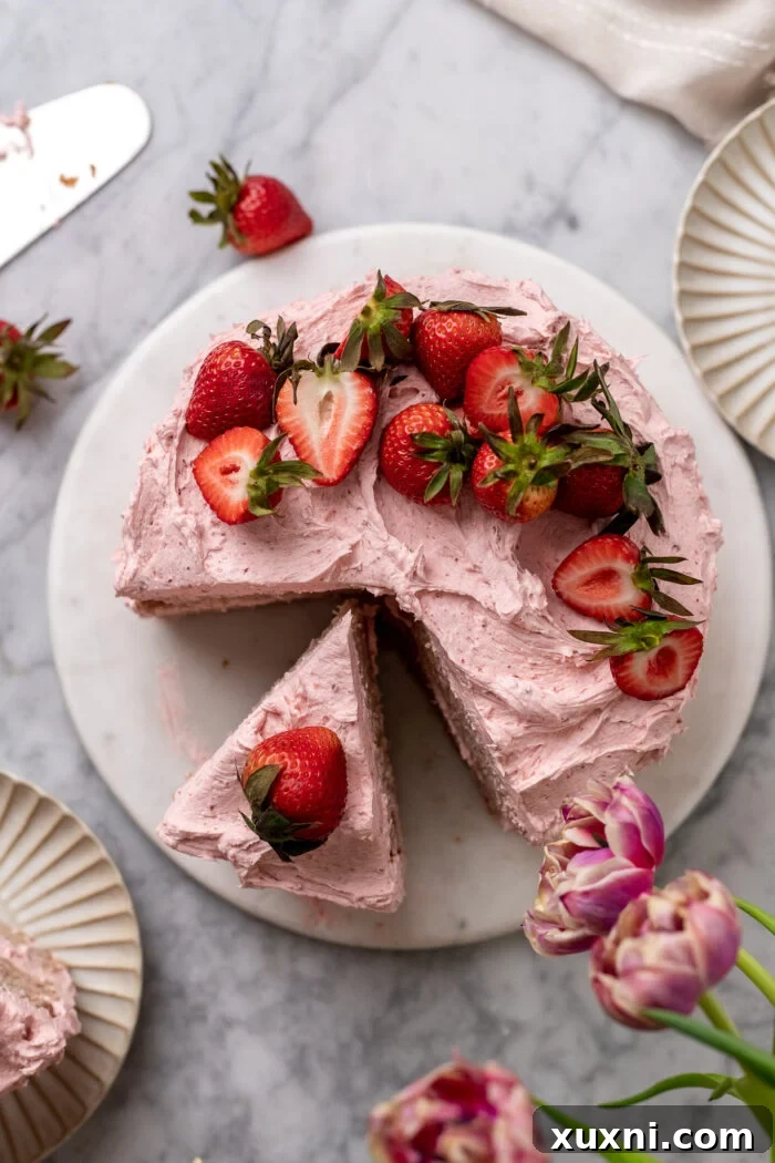 Close-up of a perfectly sliced vegan strawberry cake, showcasing its delicate layers and rich frosting.