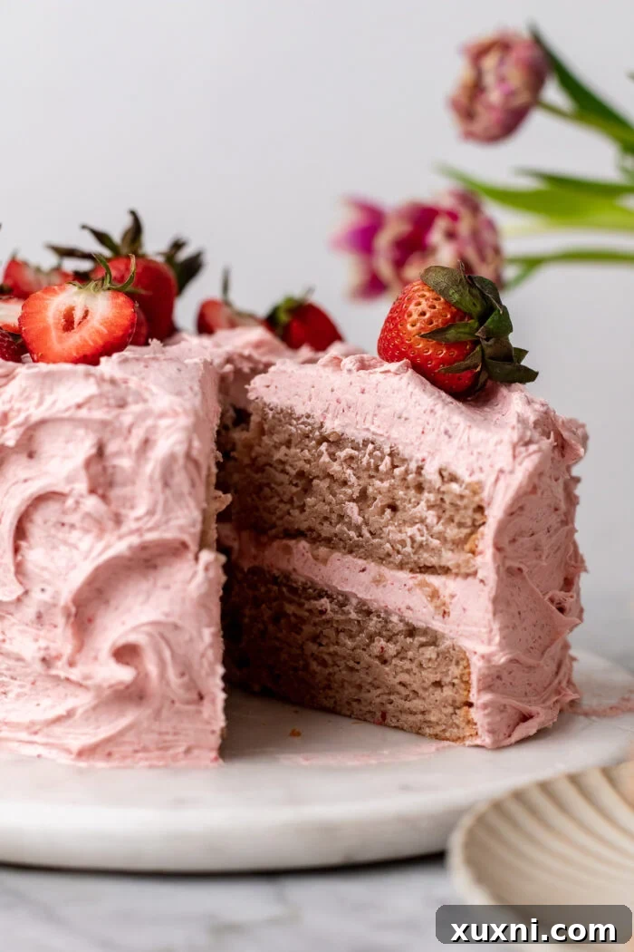 An enticing slice of vegan strawberry cake rests on a rustic pastry board, ready to be devoured.
