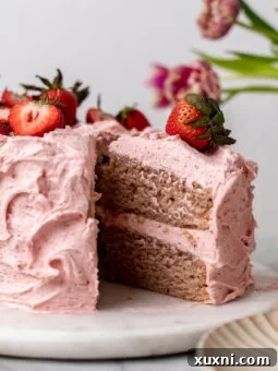A tantalizing slice of vegan strawberry cake on a rustic pastry board, ready to be devoured.