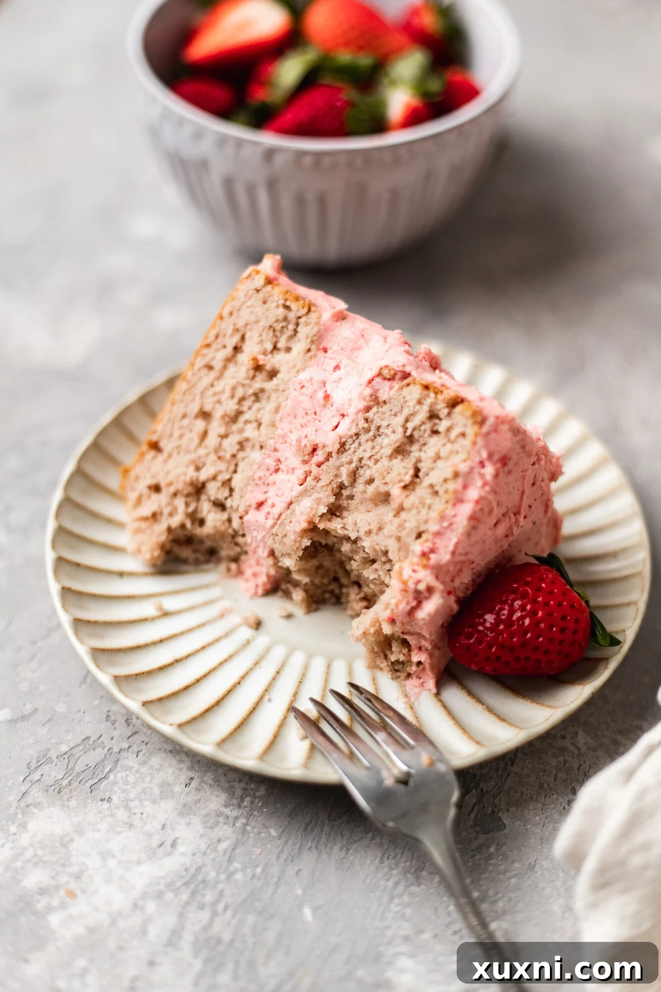 A partially eaten slice of vegan strawberry cake, demonstrating its irresistible appeal and tender layers.