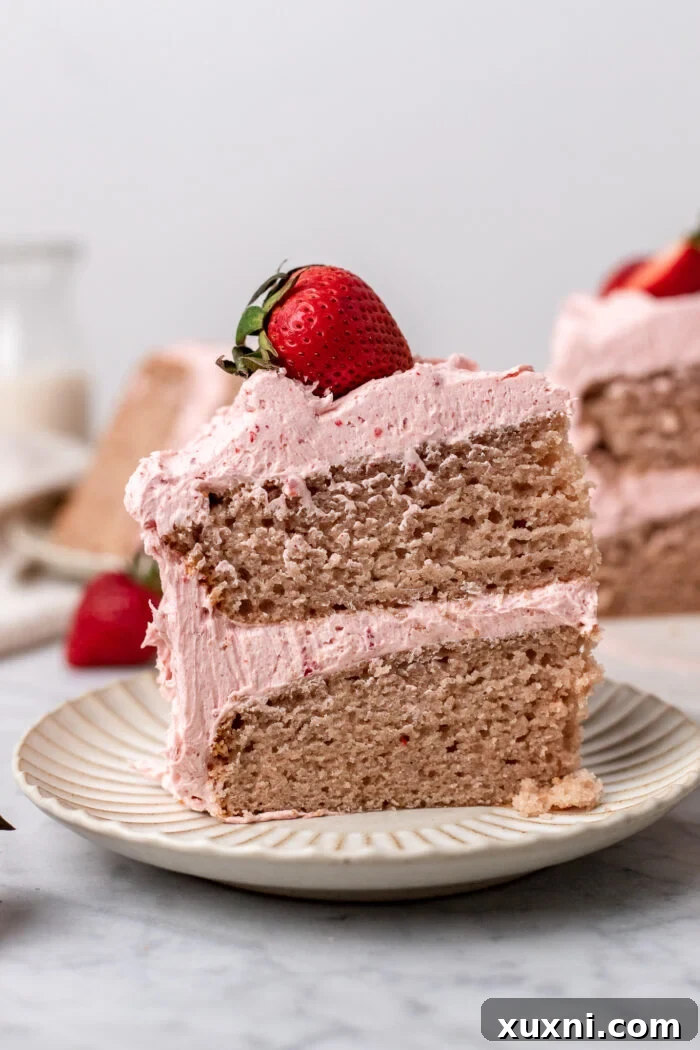 A tantalizing slice of strawberry cake on a pristine white plate, showcasing its fluffy interior.