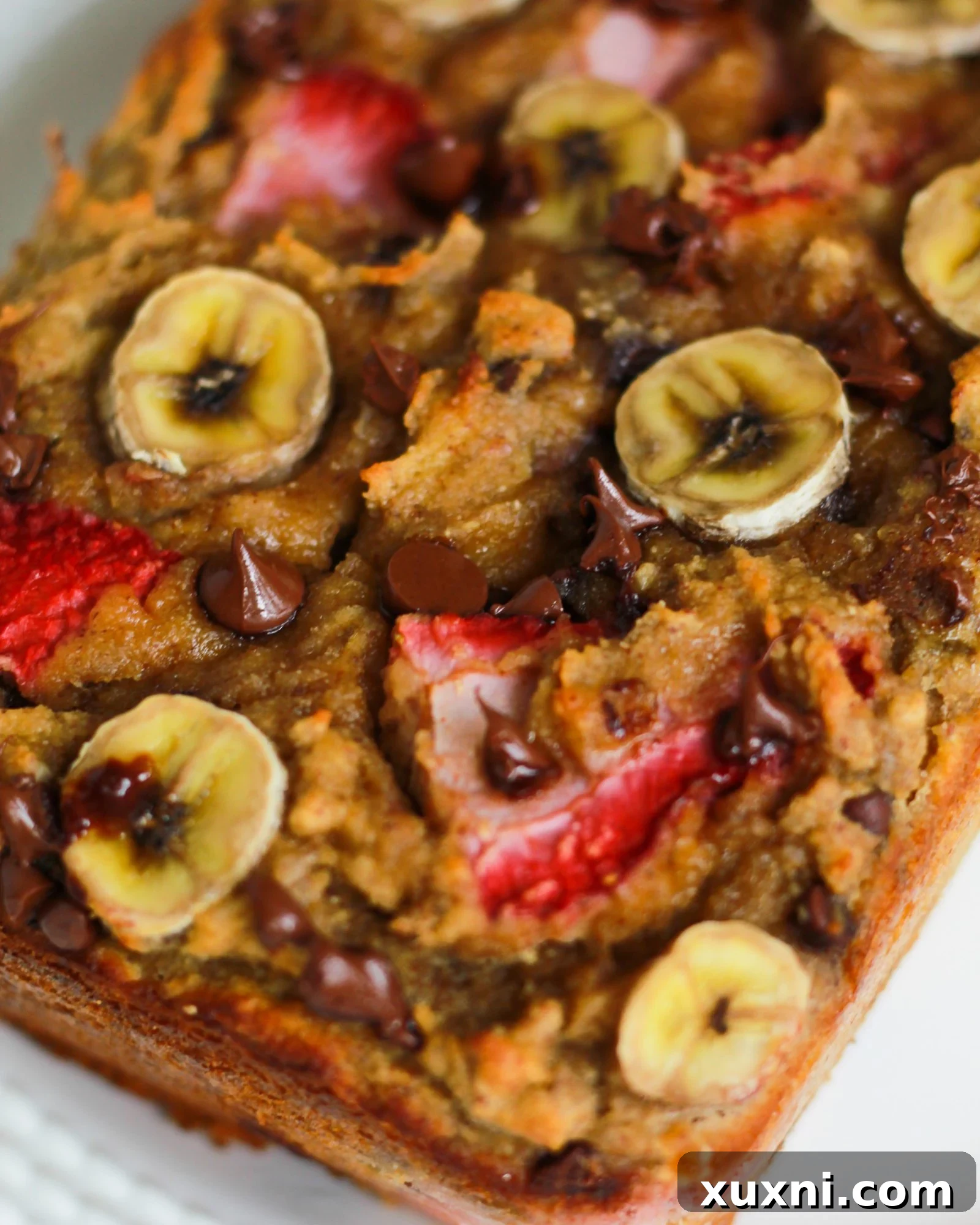 Irresistible chocolate chunks visible within a slice of strawberry banana bread, inviting a delightful experience.