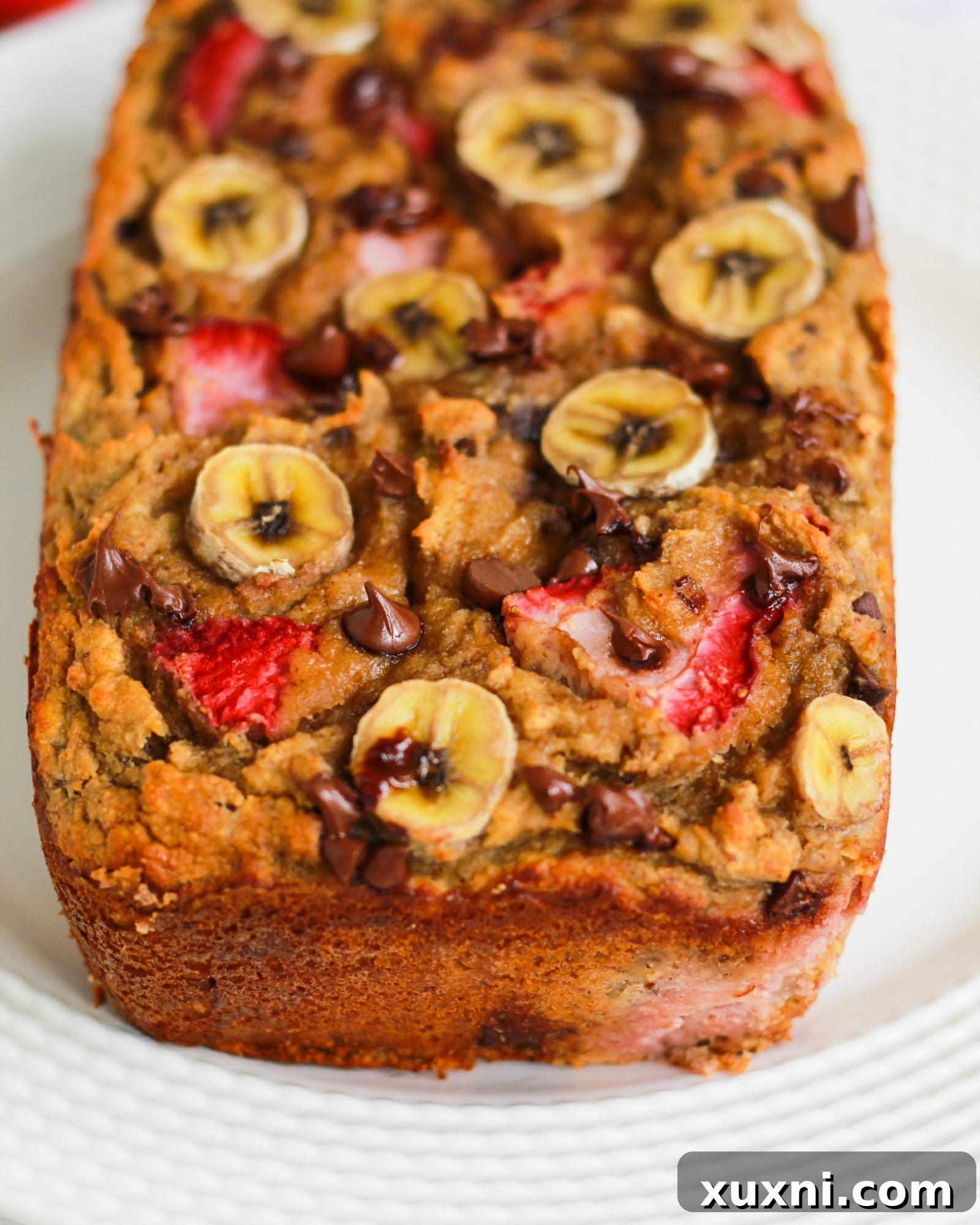 All the fresh and wholesome ingredients for strawberry banana bread meticulously laid out on a wooden table.
