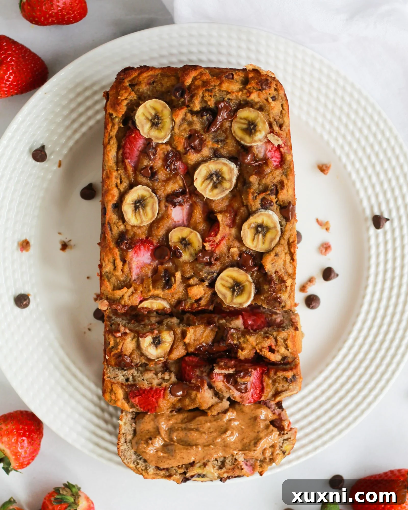 An artful arrangement of freshly baked strawberry banana bread slices on a white plate, ready to be enjoyed.