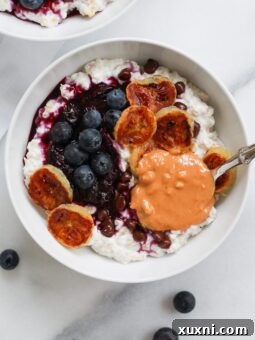 Creamy bowl of oatmeal with peanut butter on white marble