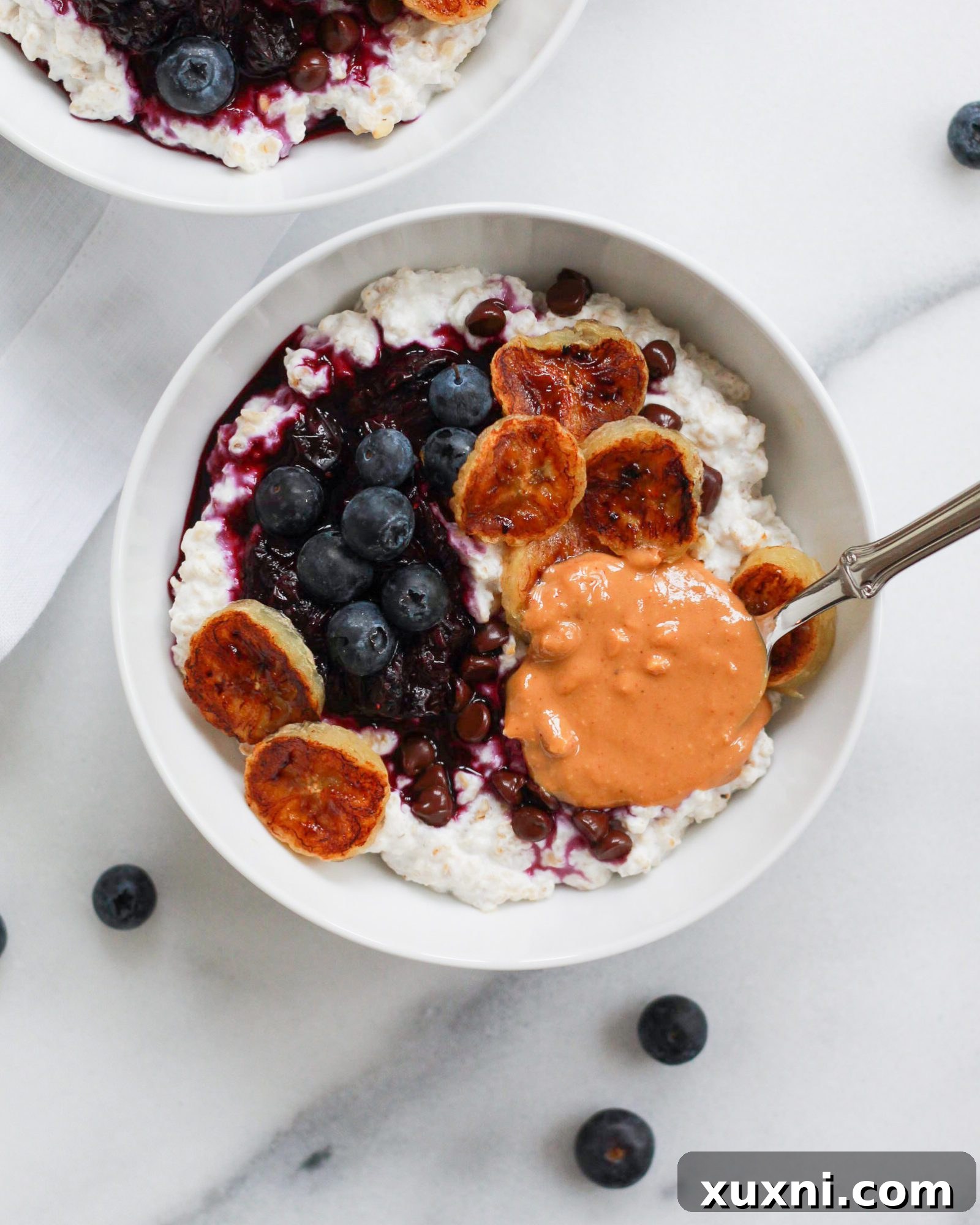Oatmeal bowl with a spoon overflowing with peanut butter