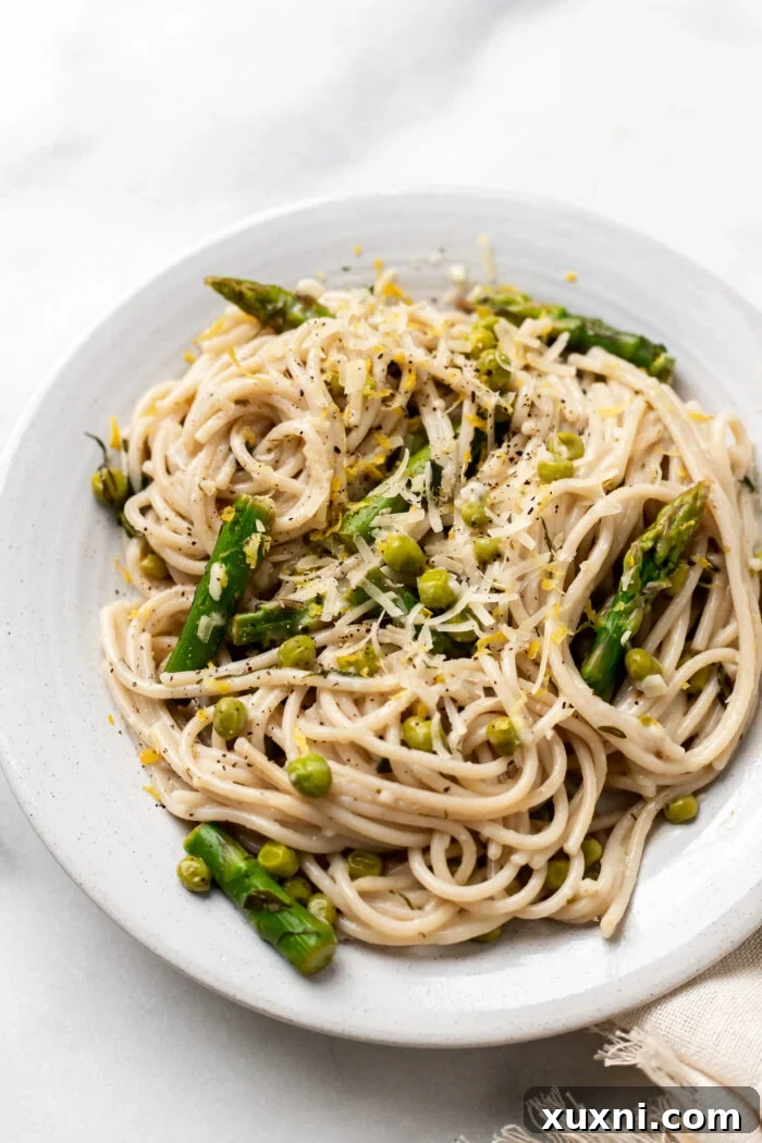 plate of vegan lemon pasta with asparagus and peas