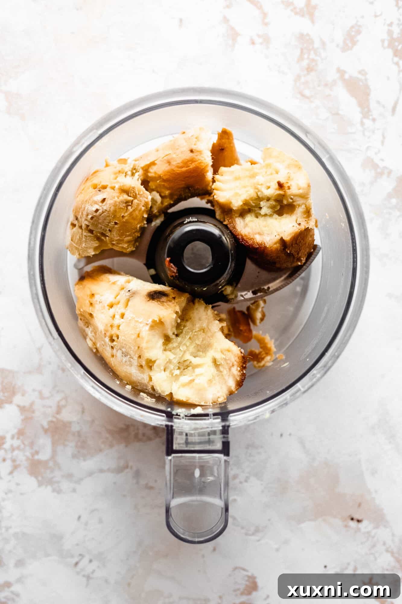 Baked sweet potatoes being added to a food processor